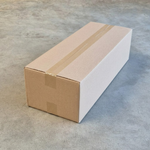 Carton d'expédition fermé contenant des sacs SOS brun 1 feuille, posé sur sol béton