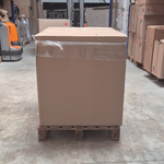 Palette de barquettes carton kraft empilées dans un entrepôt logistique avec transpalette en arrière-plan