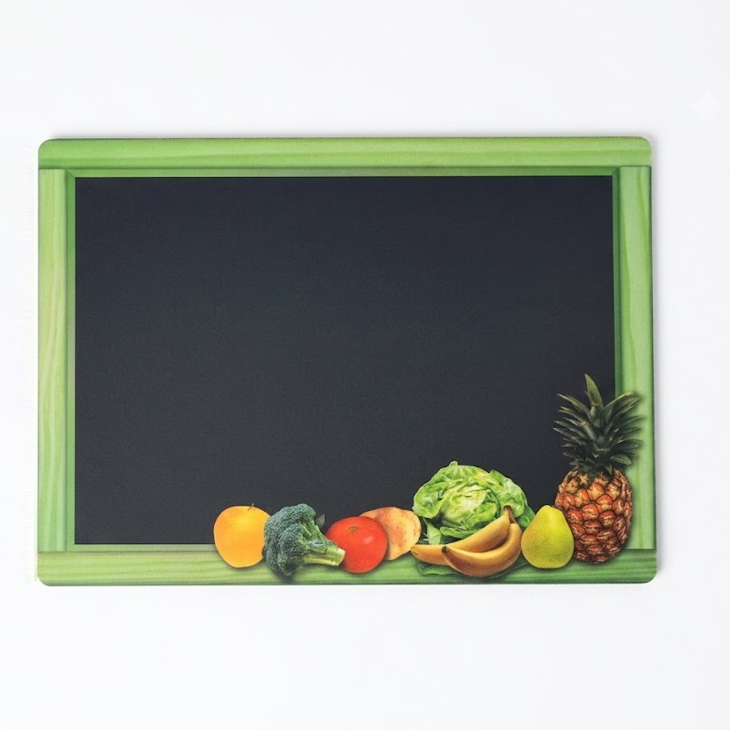 Pancarte ardoise noire encadrée de vert avec fruits et légumes disposés en bas : orange, brocoli, tomate, laitue, bananes, poire et ananas