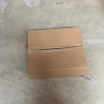 Carton d'emballage fermé contenant des sacs carottes 2kg impression rouge, posé sur sol béton